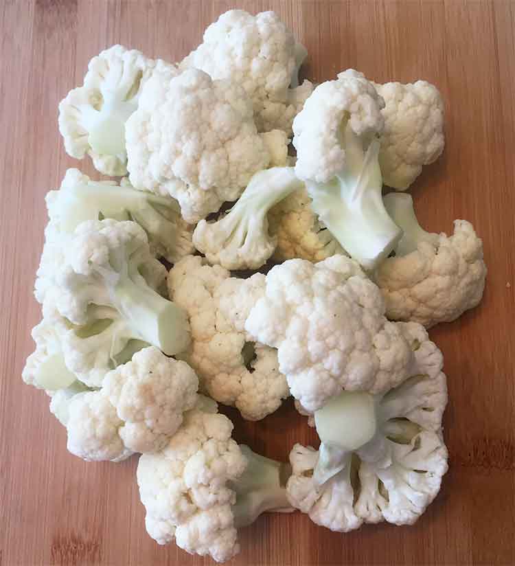 photo of cauliflower florets on a board. Keto-cauliflower-egg-fried-rice